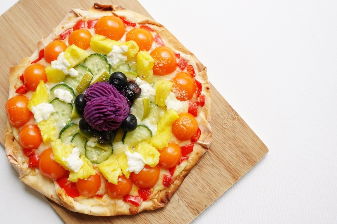 Pizza with assorted vegetables and fruits